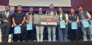 Estudiantes universitarios trabajando en equipo durante un hackathon, análisis colaborativo con laptops.